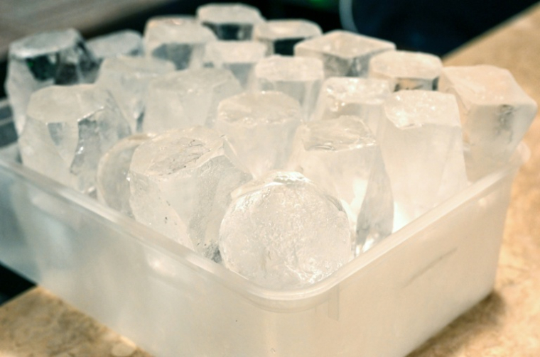Des glaçons produits par l'usine Kuramoto Ice sur le comptoir d'un bar à Melbourne, le 29 juillet 2026 en Australie ( AFP / William WEST )
