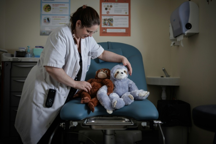 Céline Cazaux, infirmière, dispose des peluches sur une table d'examens gynécologiques de l'unité d'accueil pour enfants en Danger (Uaped) installée dans le centre hospitalier sud francilien (CHSF) à Corbeil-Essonnes, près de Paris, le 30 juin 2026 ( AFP / Simon WOHLFAHRT )