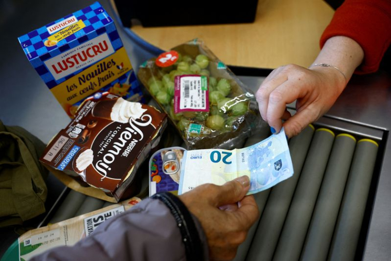 Une femme paie avec un billet de vingt euros à la caisse d'un supermarché à Chanverrie