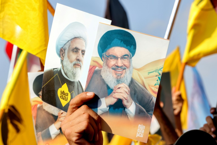 Des portraits du chef du Hezbollah assassiné Hassan Nasrallah (d) et du dirigeant actuel Naïm Qassem (g) lors d'une cérémonie marquant le premier anniversaire de l'assassinat de Nasrallah par Israël, dans la banlieue sud de Beyrouth, le 27 septembre 2025 au Liban ( AFP / Anwar AMRO )