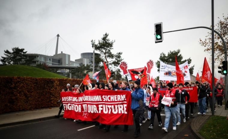 Des employés du constructeur automobile allemand Volkswagen déploient une banderole portant l'inscription "Fight for our Future" lors d'une manifestation à l'usine Volkswagen de Wolfsburg, dans le nord de l'Allemagne, le 21 novembre 2024 ( AFP / Ronny HARTMANN )