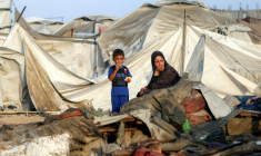 Une femme et son enfant parmi les débris d'un camp de déplacés palestiniens après une frappe israélienne, près de Khan Younès, dans le sud de la bande de Gaza le 28 juillet 2025 ( AFP / - )