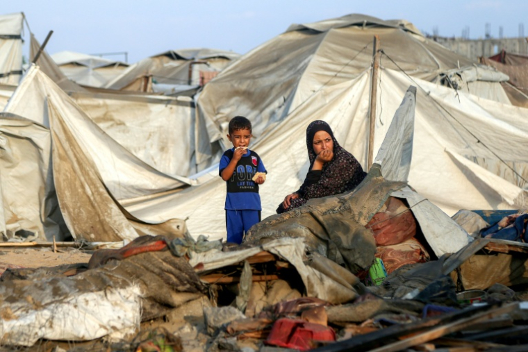Une femme et son enfant parmi les débris d'un camp de déplacés palestiniens après une frappe israélienne, près de Khan Younès, dans le sud de la bande de Gaza le 28 juillet 2025 ( AFP / - )