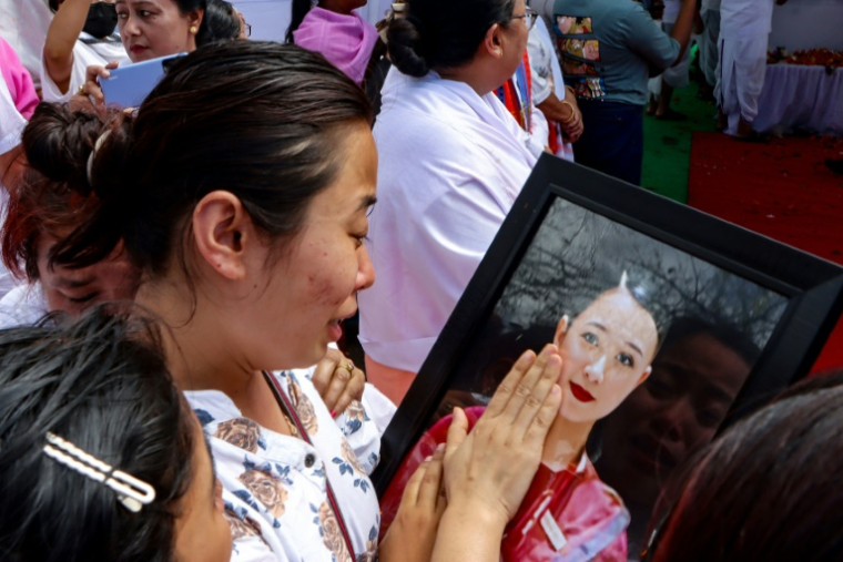 Kongbrailatpam Gitanjali Sharma, sœur d'une membre d'équipage du vol AI171 d'Air India, pleure en caressant son portrait lors de la cérémonie funéraire à Imphal le 22 juin 2022 ( AFP / VISHMA AHANTHEM )