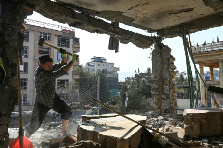 Un Afghan enlève des débris dans un logement endommagé lors d'une frappe aérienne, le 16 octobre 2025 à Kaboul ( AFP / Wakil KOHSAR )