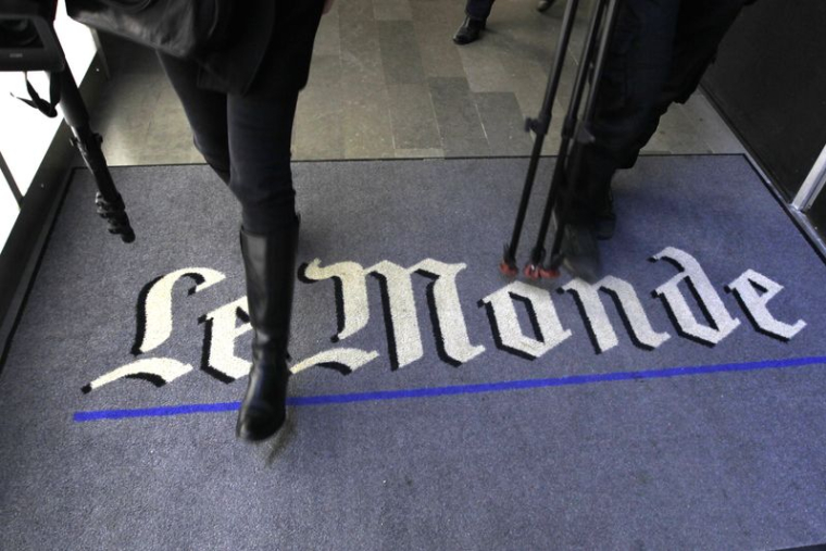 Un journaliste marche sur le logo du quotidien français Le Monde dans leurs bureaux à Paris