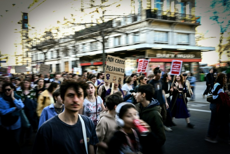 Une manifestante tient une pancarte sur laquelle on peut lire "Mon corps, mes droits" (centre) lors d'une marche de protestation organisée à l'occasion de la Journée internationale des droits des femmes 2025, à Paris, le 8 mars 2025 ( AFP / MARTIN BUREAU )