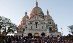 Des touristes assis sur les escaliers devant la basilique du Sacré-Cœur à Montmartre