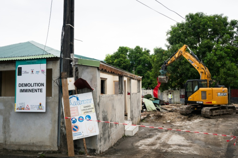 Un engin démantèle un bâtiment dans un quartier des Abymes en Guadeloupe qui doit être reconstruit, le 9 avril 2025 ( AFP / Carla Bernhardt )