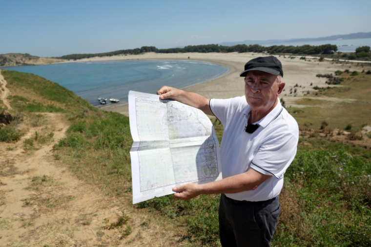 Minella Balliu, 68 ans, l'une des personnes revendiquant la propriété de terres à Zvernec, montre une vieille carte près d'une plage de Zvernec, près de Vlora, le 18 juin 2026 ( AFP / Adnan Beci )