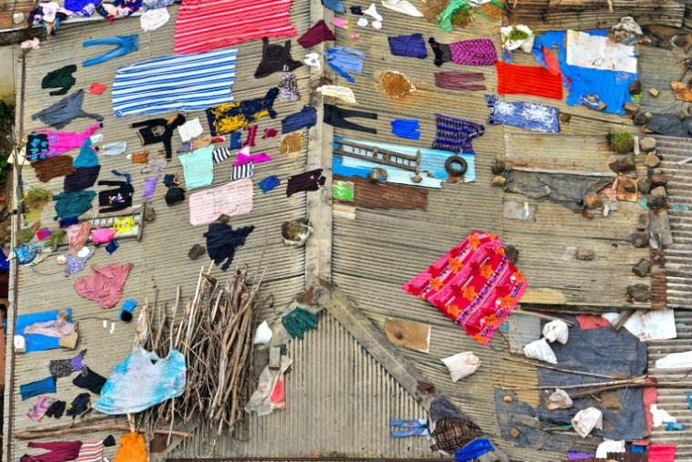 Des vêtements et autres affaires sèchent sur le toit d'une maison à Nuwara Eliya, au Sri Lanka, le 2 décembre 2025 ( AFP / Ishara S. KODIKARA )