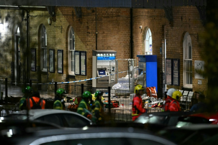 Policiers et secouristes devant la gare de Huntingdon sur les lieux d'une attaque à l'arme blanche qui a fait au moins 10 blessés dont neuf graves dans un train en direction de Londres, dans l'est de l'Angleterre, le 1er novembre 2025 ( AFP / JUSTIN TALLIS )
