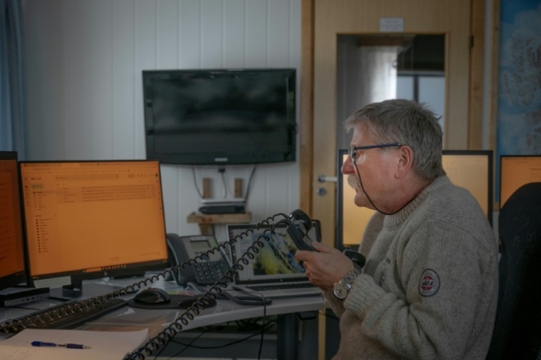 Le météorologue norvégien Trond Robertsen indique les prévisions météorologiques par radio aux bateaux naviguant dans la zone orientale de la mer de Barents, depuis la station météorologique de la côte nord du territoire norvégien reculé de l'île aux Ours (Bjornoya), Le 5 avril 2025 ( AFP / Olivier MORIN )