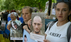 Des Ukrainiens brandissent des portraits de leurs parents captifs ou disparus dans l'espoir qu'ils seront reconnus par l'un ou l'autre des prisonniers de guerre libérés dans le cadre d'un échange avec la Russie, le 23 mai 2025  ( AFP / Genya SAVILOV )