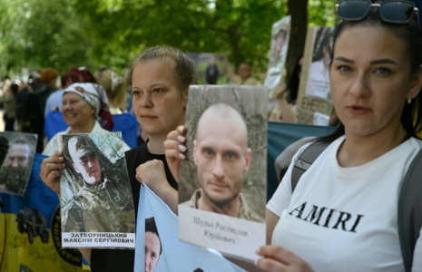 Des Ukrainiens brandissent des portraits de leurs parents captifs ou disparus dans l'espoir qu'ils seront reconnus par l'un ou l'autre des prisonniers de guerre libérés dans le cadre d'un échange avec la Russie, le 23 mai 2025  ( AFP / Genya SAVILOV )