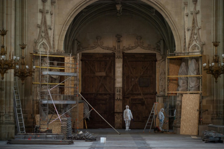 Des employés de la Direction régionale des affaires culturelles (Drac) devant la cathédrale Saint-Pierre-et-Saint-Paul de Nantes, le 30 juin 2021, endommagée par un incendie volontaire en juillet 2020 ( AFP / LOIC VENANCE )