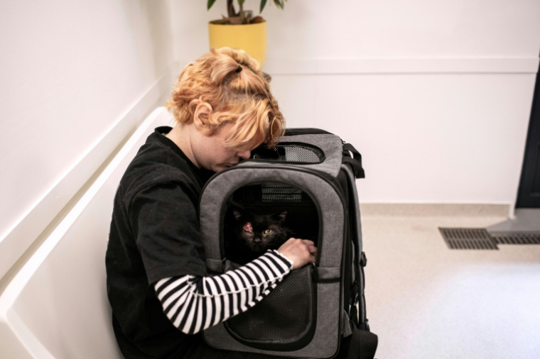Hélèna caresse son chat Odin, atteint d'un cancer de la paupière et de la gorge, lors d'un rendez-vous chez le vétérinaire à l'hôpital vétérinaire de Maison-Alfort, le 9 juin 2026 dans le Val-de-Marne ( AFP / Behrouz MEHRI )
