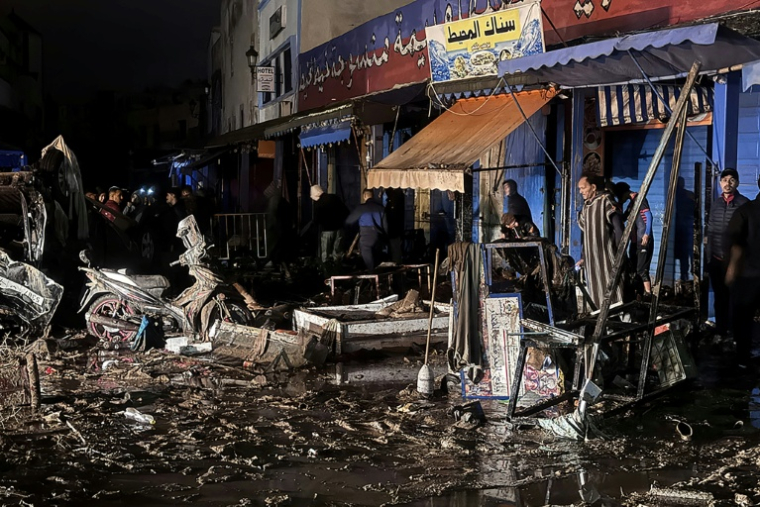 Des personnes marchent parmi les débris dans la ville côtière marocaine de Safi après une crue soudaine causée par des pluies torrentielles, le 14 décembre. ( AFP / - )