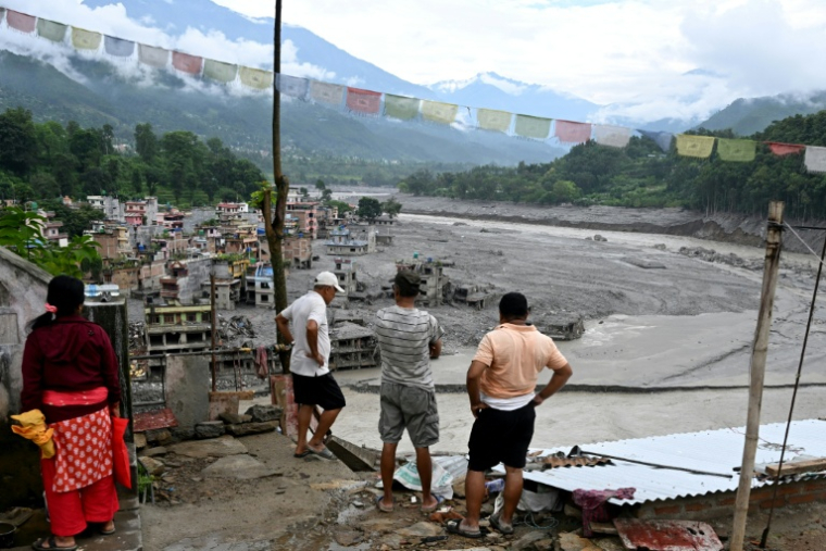 Des habitants observent des maisons endommagées par des crues soudaines à Trishuli Center, dans le district de Nuwakot, le 31 août 2026 au Népal ( AFP / Arun SANKAR )