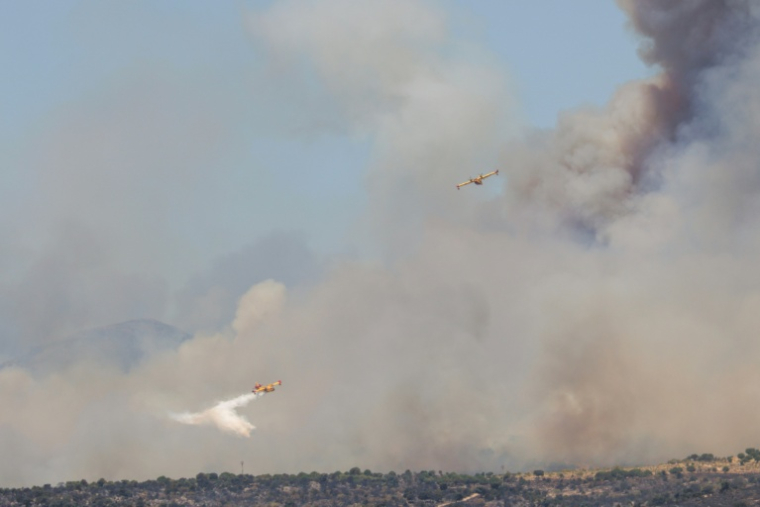 Des avions de lutte contre les incendies Canadair de l'armée de l'air espagnole larguent de l'eau sur un feu de forêt près de San Martín de Valdeiglesias, à l'ouest de Madrid, le 24 juillet 2026.   ( AFP / Pierre-Philippe MARCOU )