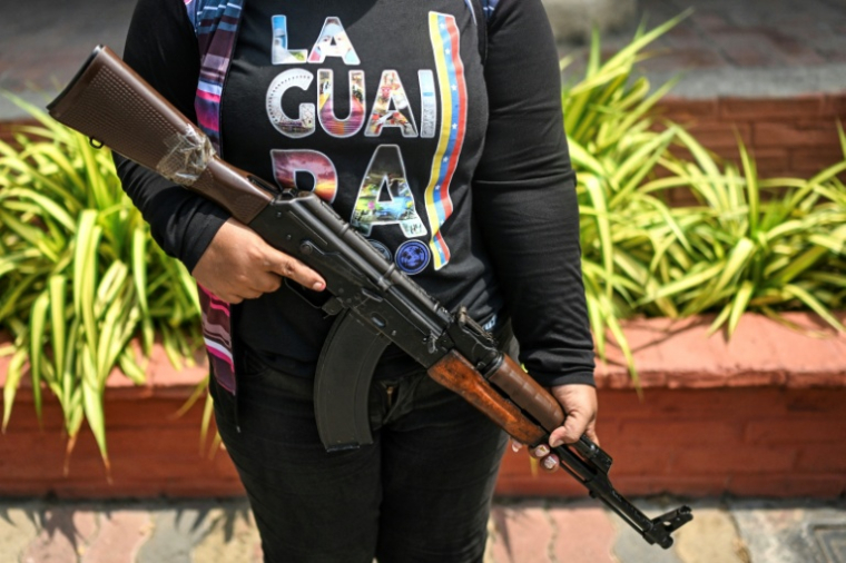 Une membre de la Milice nationale bolivarienne tient un fusil lors d'un entraînement militaire à La Guaira, au Venezuela, le 8 octobre 2025 ( AFP / Juan BARRETO )