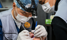 Un dentiste examine la bouche d'un eenfant dans une clinique dentaire mobile à Oulan-Bator, le 28 août 2026  ( AFP / Hector RETAMAL )