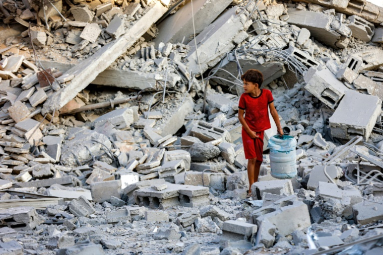 Un enfant fouille les décombres d'une tour d'habitation détruite par un bombardement israélien à Gaza-ville, le 9 septembre 2025 ( AFP / Omar AL-QATTAA )