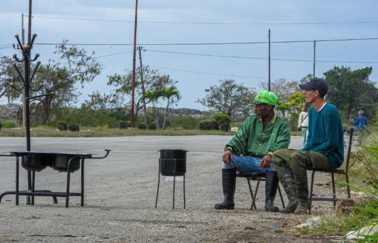 Des hommes vendent des braseros artisanaux sur une route de la périphérie de La Havane, le 6 février 2026  ( AFP / ADALBERTO ROQUE )
