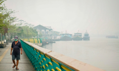 Un homme portant un masque marche le long d’une berge tandis qu’un brouillard dû aux feux de forêt et de végétation enveloppe le village de Benua Melayu Laut, à Pontianak,à Bornéo en Indonésie, le 17 septembre 2026 ( AFP / DITO )