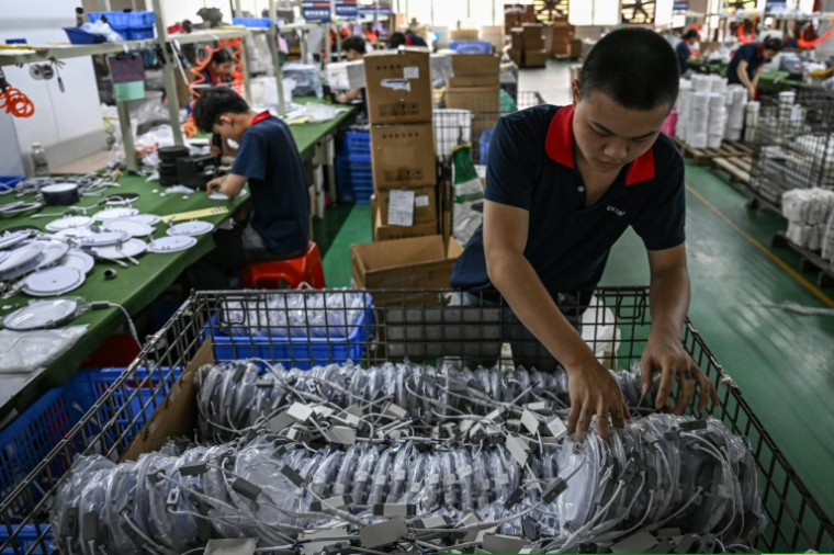 Des employés travaillent sur une ligne de production de l'usine Wosen, un fabricant d'éclairages LED, le 17 avril 2025 à Zhongshan, dans la province du Guangdong, dans le sud de la Chine ( AFP / JADE GAO )