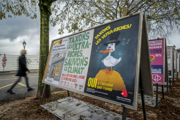 Des affiches électorales en faveur d'une initiative visant à taxer les plus riches afin de financer la lutte du pays contre le changement climatique dans une rue à Genève, le 25 novembre 2025 en Suisse ( AFP / Fabrice COFFRINI )