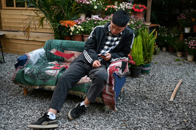 Un Chinois se repose dans une "maison de retraite pour jeunes" à Dali, dans la province du Yunnan, dans le sud-ouest de la Chine, le 2 avril 2025 ( AFP / GREG BAKER )