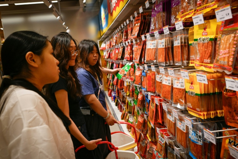 Des clientes choisissent des lamelles épicées dans un marché à Changsha, dans la province du Hunan, le 17 juin 2026 dans le centre de la Chine ( AFP / WANG Zhao )