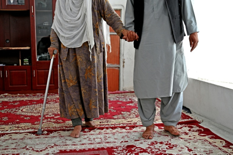 Mohammad et sa mère, banlieue de Kaboul, le 24 août 2026 ( AFP / Wakil KOHSAR )
