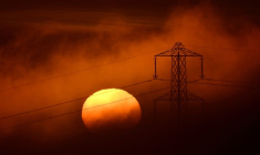 Le soleil se couche derrière un pylône électrique près de Petersfield, en Grande-Bretagne