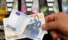 Des billets de banque devant un tiroir-caisse