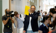 David G., animateur périscolaire, se cache le visage avec un dossier à son arrivée au tribunal où il doit être jugé pour agressions sexuelles sur neuf enfants, le 26 mai 2026 ( AFP / SIMON WOHLFAHRT )