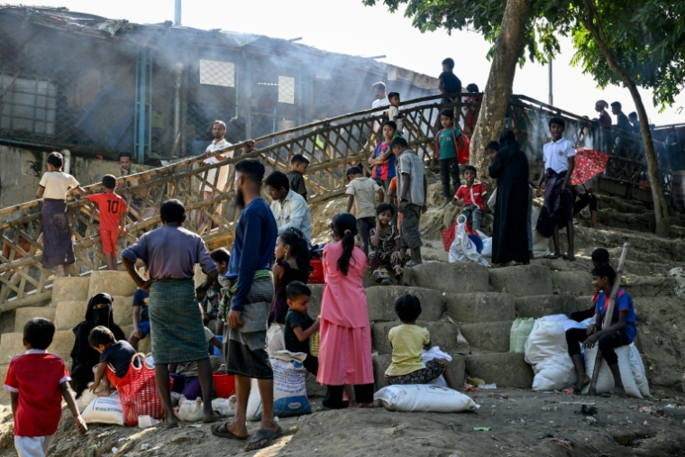 Des réfugiés rohingyas attendant devant un centre de distribution après avoir reçu des secours humanitaires au camp de réfugiés de Kutupalong, à Cox's Bazar au Bangladesh, le 20 décembre 2025 ( AFP / Munir UZ ZAMAN )