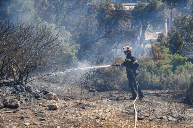 Un pompier au sud de la ville de Réthymnon, sur l'île grecque de Crète, le 30 juillet 2026 ( AFP / Costas METAXAKIS )