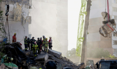 Des secouristes sur le site d'une frappe russe ayant partiellement détruit un immeuble résidentiel à Kiev, le 14 mai 2026  ( AFP / Tetiana DZHAFAROVA )