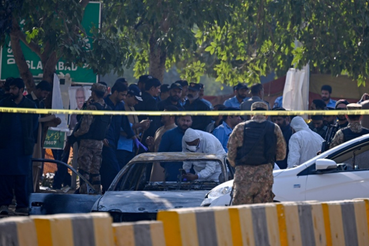Des policiers examinent une voiture après un attentat-suicide à Islamabad, le 11 novembre 2025 au Pakistan ( AFP / Farooq NAEEM )