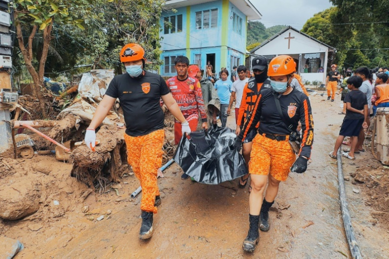 Photo prise le 26 septembre 2025 et publiée le 27 septembre par le Bureau de protection contre les incendies de la province de Biliran (BFP-Biliran) de sauveteurs transportant le corps d'une victime d'un glissement de terrain lors du passage de la violente tempête tropicale Bualoi à Kawayan, aux Philippines ( Bureau de protection contre les incendies de la province de Biliran (BFP-Biliran) / Handout )