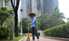 Un balayeur devant les tours sinistrées du complexe résidentiel de complexe résidentiel de Wang Fuk Court à Hong Kong, le 20 avril 2026 ( AFP / Peter PARKS )