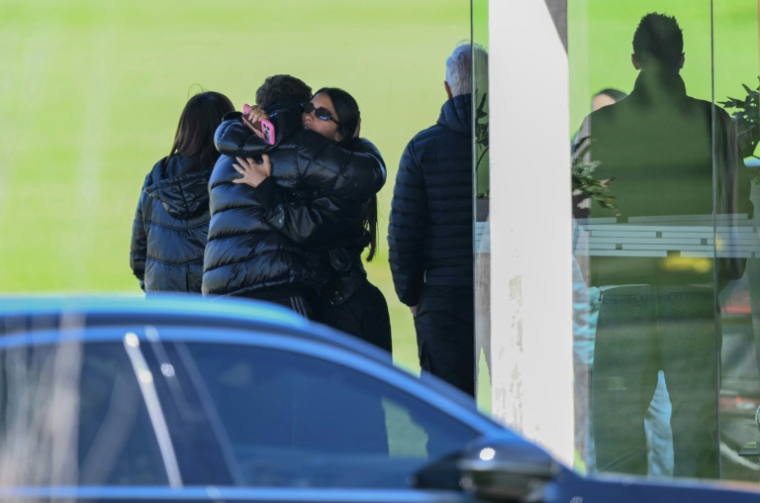L'épouse de la star du foot Lionel Messi, Antonela Roccuzzo, étreint un proche lors d'une cérémonie en l'honneur de son beau-père Jorge Messi, décédé la veille, le 9 août 2026 près de Rosario en Argentine ( AFP / Luis ROBAYO )