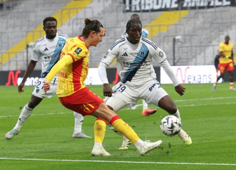 Le Lensois Florian Thauvin (g) aux prises avec le défenseur du Paris FC Nhoa Sangui lors de la victoire des Sang et Or 2-1, le 19 octobre 2025 à Lens ( AFP / Francois LO PRESTI )