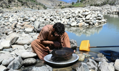Un homme cherche de l'or en utilisant la technique traditionnelle de l'orpaillage, après avoir trié les pépites extraites des pierres de la montagne, provenant du lit de la rivière Kunar, dans le district de Naray de la province de Kunar, le 13 avril 2026 en Afghanistan ( AFP / Wakil KOHSAR )