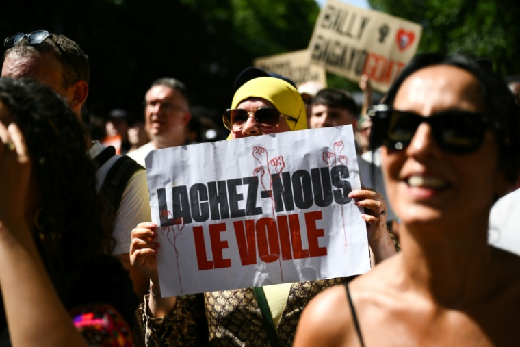 Une manifestante tient une affiche "Lâchez-nous le voile" lors d'une marche contre le racisme et l'extrême droite, le 21 juin 2026 à Paris ( AFP / Arnaud FINISTRE )