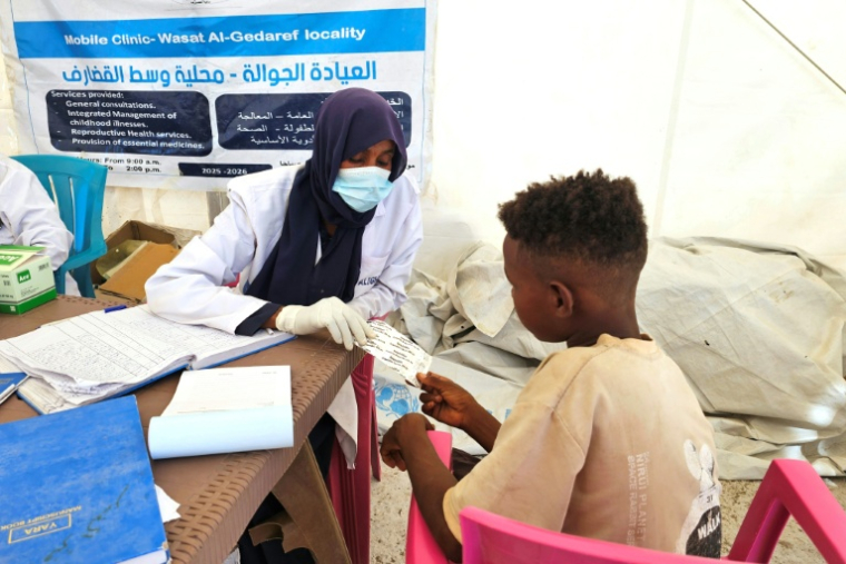 Un enfant soudanais déplacé reçoit des médicaments dans un dispensaire installé dans le camp d'Abou al-Naga, dans l'Etat de Gedaref à environ 400 kilomètres à l'est de Khartoum, le 30 décembre 2025 ( AFP / Abdulrahman GUMAA )