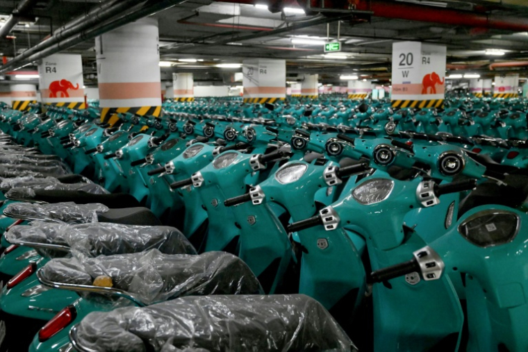 Des scooters électriques neufs stockés dans un parking de Hanoi, le 17 juillet 2025 ( AFP / Nhac NGUYEN )