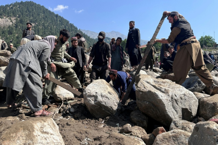 Des habitants fouillent les décombres de boutiques détruites par des crues soudaines à Parun, dans la province du Nouristan, le 21 juillet 2026 en Afghanistan ( AFP / AFP )